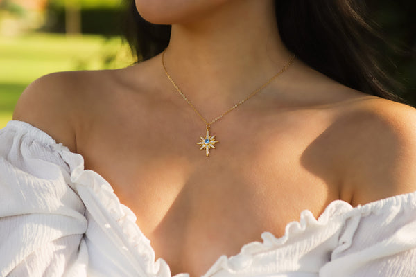Girl wearing a star necklace with march birthstone, aquamarine